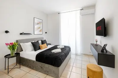 a bedroom with a bed in a white room at V HOME San Lorenzo in Rome
