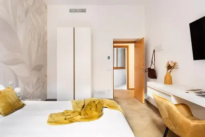 a bedroom with a bed with a yellow blanket on it at Idyllia - Magnificent Central Apartment in Rome