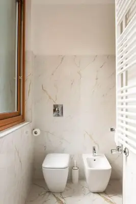 a white bathroom with a toilet and a sink at Idyllia - Magnificent Central Apartment in Rome