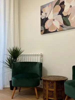 a living room with a green chair and a table at Maison Almo Guesthouse in Rome