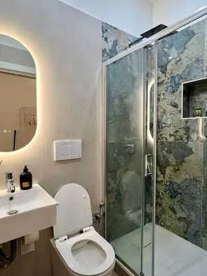 a bathroom with a shower and a toilet and a sink at Maison Almo Guesthouse in Rome