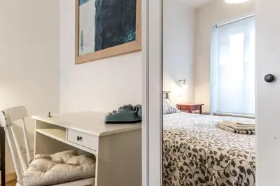 a small bedroom with a bed and a desk at The ancient volute guest house in Rome