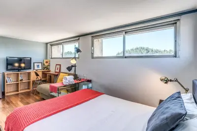 a bedroom with a bed and a desk and two windows at Romantic Vatican Attic Villa Pamphili in Rome