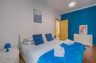 a bedroom with a large bed with blue walls at Orange Blue House 1Bedr Metro Re di Roma in Rome
