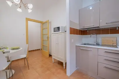 a kitchen with white cabinets and a sink and a table at Orange Blue House 1Bedr Metro Re di Roma in Rome