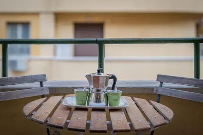 a coffee maker and two cups sitting on a table at Orange Blue House 1Bedr Metro Re di Roma in Rome