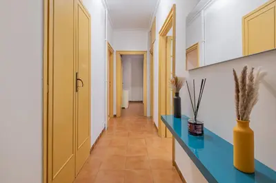 a hallway with a blue counter and a yellow door at Orange Blue House 1Bedr Metro Re di Roma in Rome