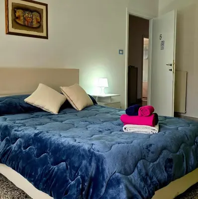 a large bed with blue sheets and pink towels on it at Domus Passerini in Rome