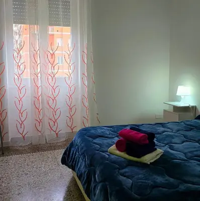 a bedroom with a blue bed with a window at Domus Passerini in Rome