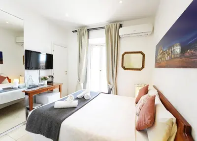 a bedroom with a bed and a desk and a television at Key Rome Center in Rome