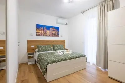 a white bedroom with a bed and a desk at Little House 15 in Rome