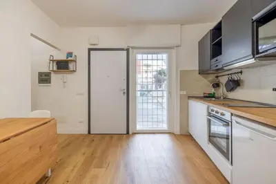 a kitchen with white appliances and a wooden floor at Little House 15 in Rome