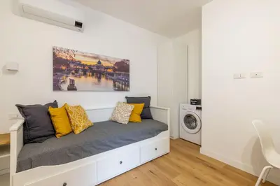 a white room with a bed with yellow pillows at Little House 15 in Rome
