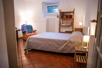 a bedroom with a bed and a chair in it at Alloggio Turistico al Villino del Melograno in Rome