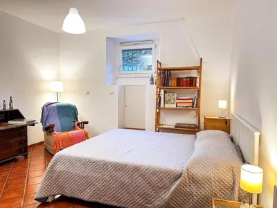 a bedroom with a bed and a desk and a chair at Alloggio Turistico al Villino del Melograno in Rome