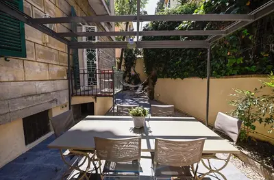 a table and chairs on a patio with a pergola at Il Giardino della Musa in Rome