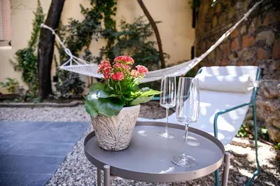 a table with two wine glasses and a vase with flowers at Il Giardino della Musa in Rome