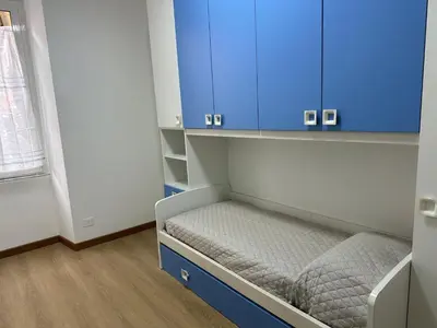 a small room with blue cabinets and a bed at Maison Niccolini Gianicolo in Rome