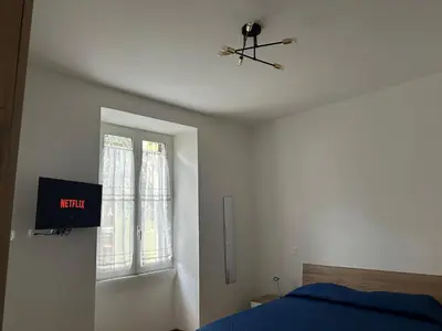 a bedroom with a blue bed and a window at Maison Niccolini Gianicolo in Rome