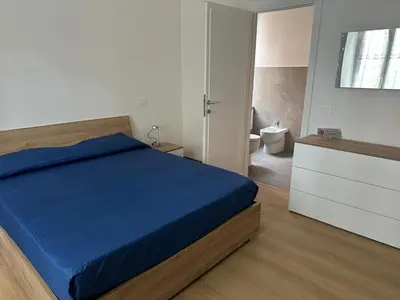 a bedroom with a blue bed and a bathroom at Maison Niccolini Gianicolo in Rome