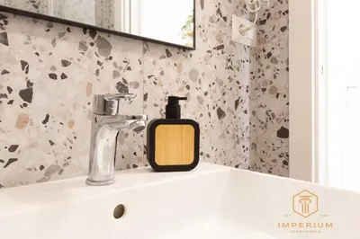 a soap dispenser sitting on a sink in a bathroom at Imperium Luxury Suites - 100mt to Metro A, 5 min to center, pvt bathroom, A-C in Rome