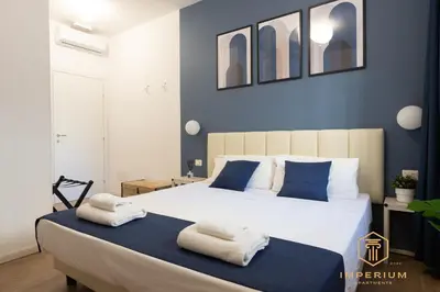 a bedroom with a large white bed with towels on it at Imperium Luxury Suites - 100mt to Metro A, 5 min to center, pvt bathroom, A-C in Rome