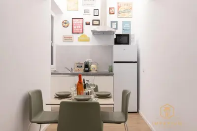a kitchen with a table with chairs and a refrigerator at Imperium Luxury Suites - 100mt to Metro A, 5 min to center, pvt bathroom, A-C in Rome