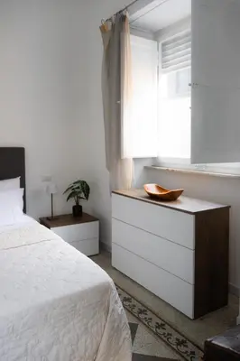 a white bedroom with a bed and a window at Imperia House in Rome