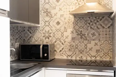 a kitchen with a microwave and a tile wall at Imperia House in Rome