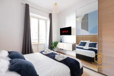 a bedroom with a large bed with blue pillows at Imperium Deluxe Apt - 300mt to Metro B, 3 bedrooms, Panoramic view, A-C in Rome