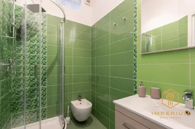 a green bathroom with a shower and a sink at Imperium Deluxe Apt - 300mt to Metro B, 3 bedrooms, Panoramic view, A-C in Rome