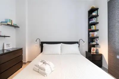 a bedroom with a white bed with a black headboard at Roma-Gemelli - Free Parking - Private Garden in Rome
