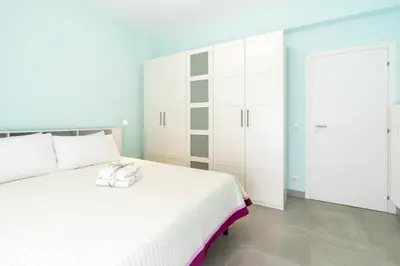 a white bedroom with a white bed and white cabinets at Roma-Gemelli - Free Parking - Private Garden in Rome