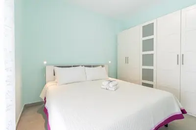 a bedroom with a white bed and white cabinets at Roma-Gemelli - Free Parking - Private Garden in Rome
