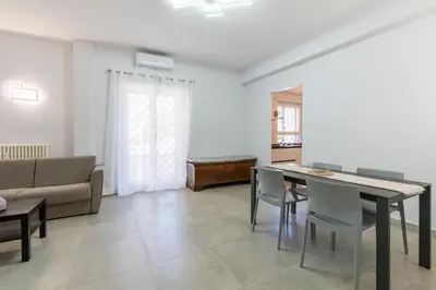 a living room with a table and chairs and a couch at Roma-Gemelli - Free Parking - Private Garden in Rome