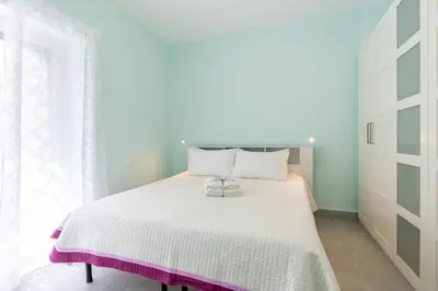 a bedroom with a white bed and a window at Roma-Gemelli - Free Parking - Private Garden in Rome