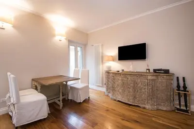 a living room with a table and a tv on the wall at Casa Belsiana in Rome