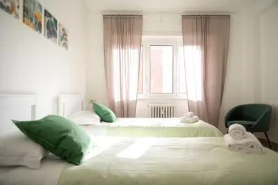 a bedroom with two beds with green pillows and a window at Vatican Fiore apartment in Rome