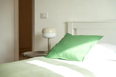 a green pillow sitting on top of a bed at Vatican Fiore apartment in Rome