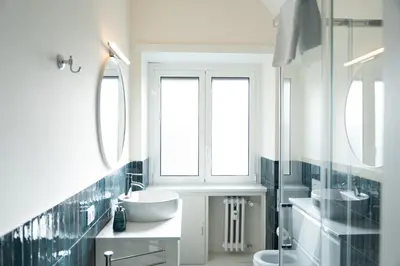 a white bathroom with two sinks and a window at Vatican Fiore apartment in Rome