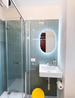 a bathroom with a sink and a glass shower at Vatican Fiore apartment in Rome