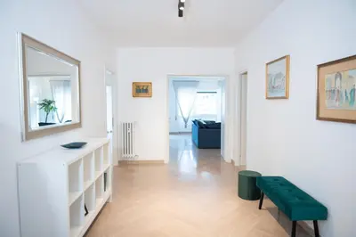 a living room with white walls and a green bench at Vatican Fiore apartment in Rome