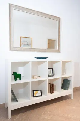 a white book shelf with a mirror on top at Vatican Fiore apartment in Rome