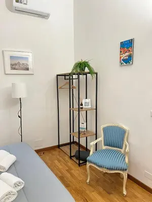 a room with a bed and a chair and a shelf at The Stay in Rome