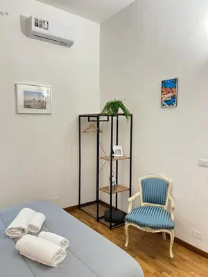 a bedroom with a bed and a blue chair at The Stay in Rome