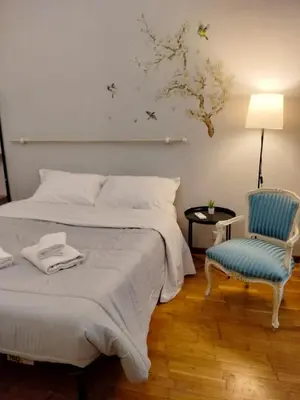 a bedroom with a bed and a blue chair at The Stay in Rome