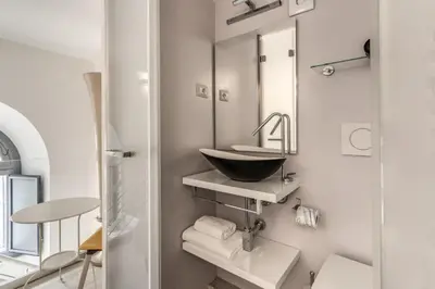 a bathroom with a sink and a mirror at Elegant flat in the Historic Rome near Colosseum! in Rome