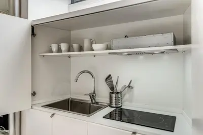 a small kitchen with a sink and shelves at Elegant flat in the Historic Rome near Colosseum! in Rome