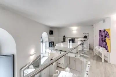 a white room with a staircase with white furniture at Elegant flat in the Historic Rome near Colosseum! in Rome