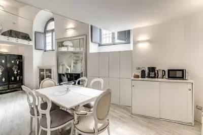 a kitchen and dining room with a white table and chairs at Elegant flat in the Historic Rome near Colosseum! in Rome